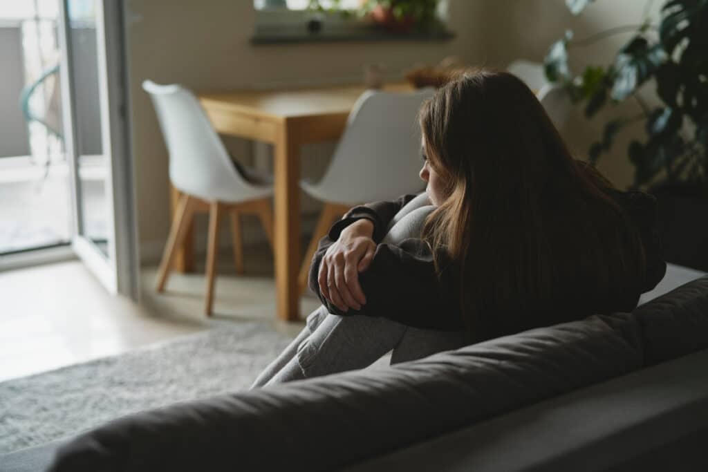 Woman struggling with seasonal depression in her room alone