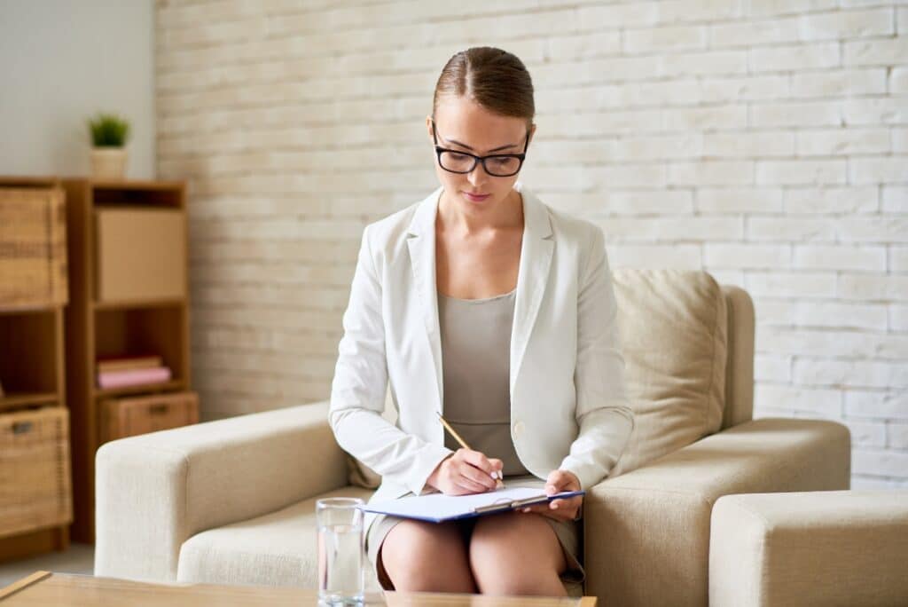 Should a Psychiatrist Be Board-Certified? - Female psychiatrist taking notes, and she is board-certified